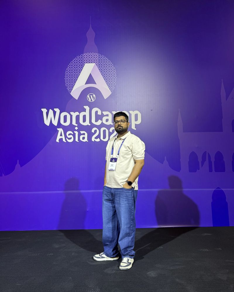 Maharshi Kushwaha standing in front of the WordCamp Asia stage backdrop